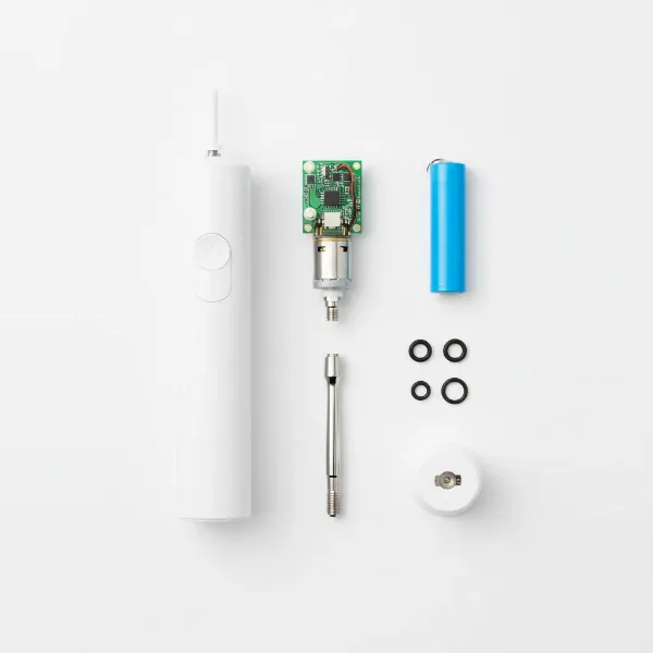 A neatly organized display of a fully disassembled electric toothbrush, showing its various internal and external parts.