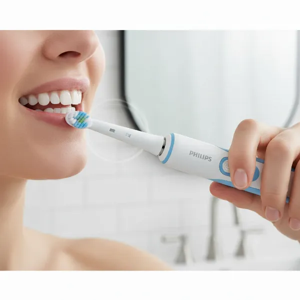 A person demonstrating the correct technique for brushing with an electric toothbrush, focusing on gentle gliding